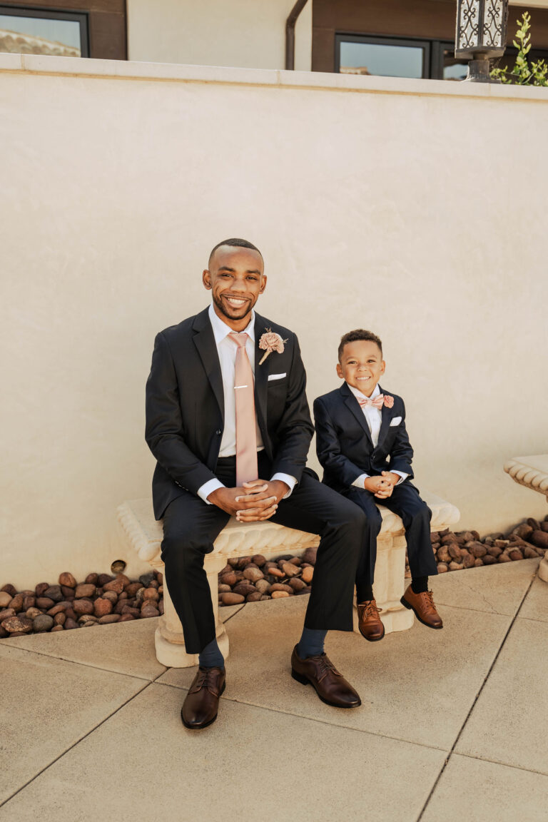a man and a young boy wearing matching suits with pink ties
