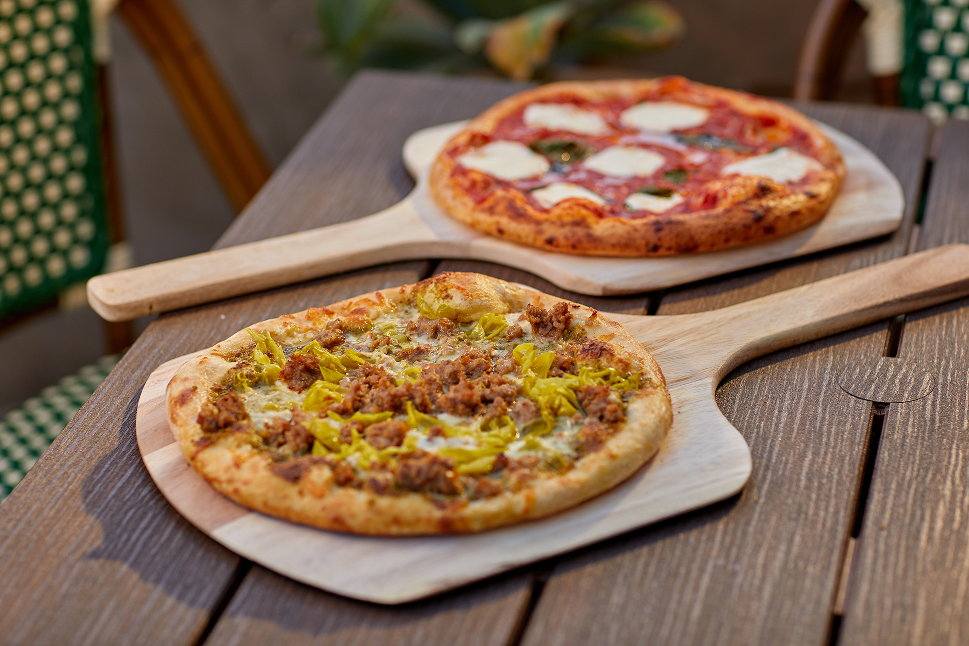 two pizzas on a pizza paddle